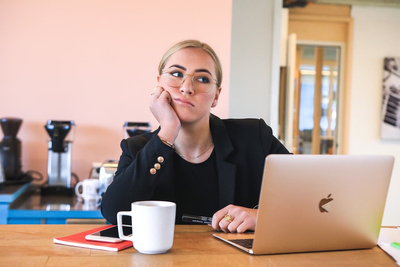 Vrouw zit verveeld achter haar laptop