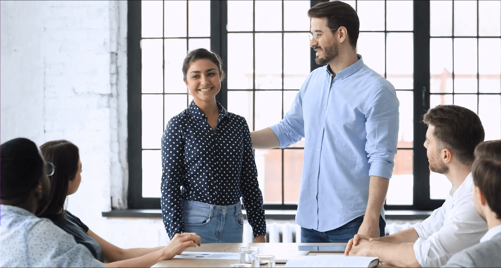 Een leidinggevende introduceert een nieuwe collega bij het team markeert het begin van diens eerste werkmaand in een ondersteunende en verwelkomende werkomgeving