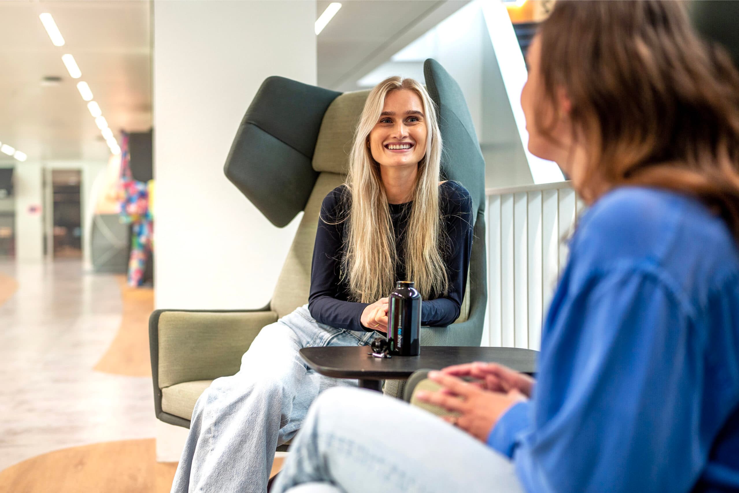 Zelfverzekerde vrouw met armen over elkaar voor haar bureau symbool voor ambitie en professionaliteit