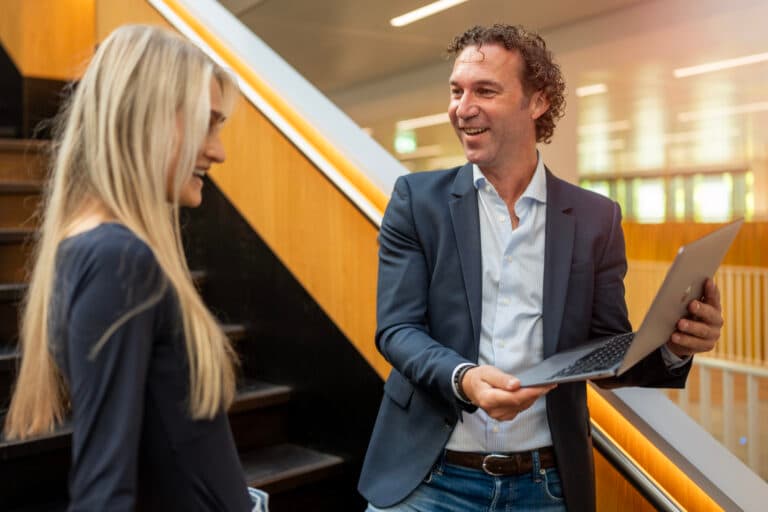 Young professional belt terwijl ze achter haar laptop op haar bureau werkt
