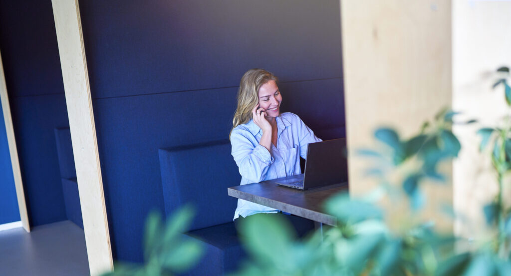 Telesales medewerker bij Budget Thuis is aan de telefoon, glimlachend.