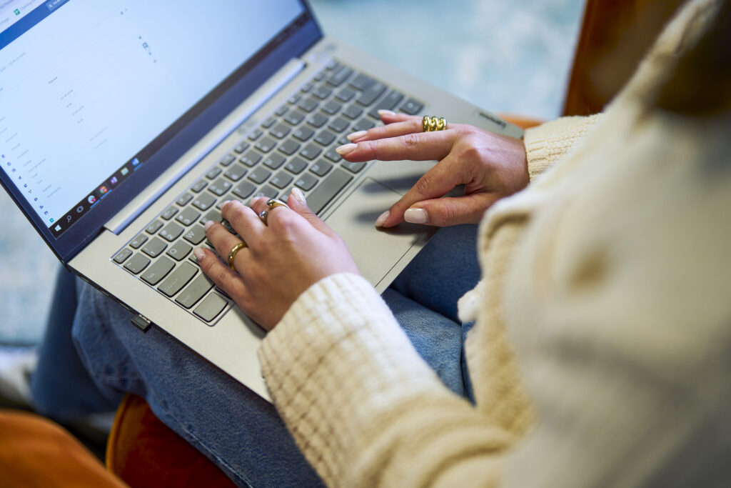 Een jonge vrouw is aan het scrollen op haar laptop.